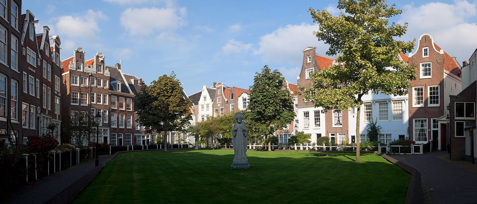 The Begijnhof courtyard: a lawn enclosed by low houses, a statue in the middle