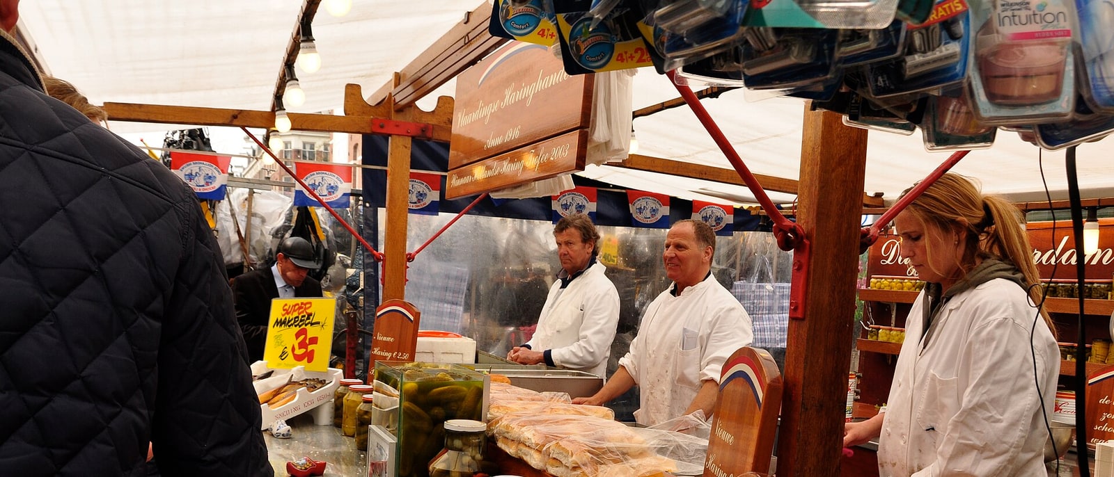 A herring stall at the market, the sellers serving from behind the counter