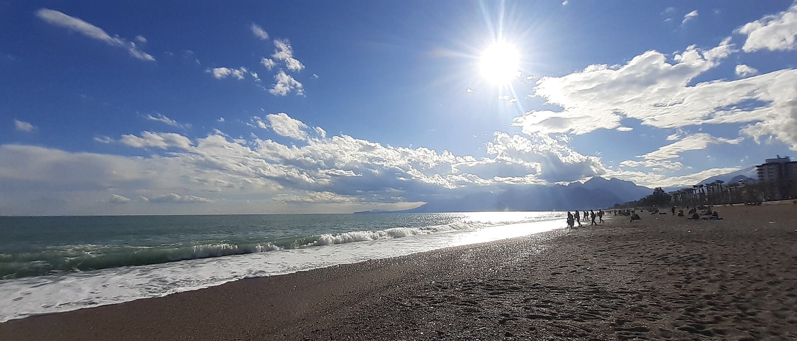 Antalya’s beach, sun high and the mountains behind