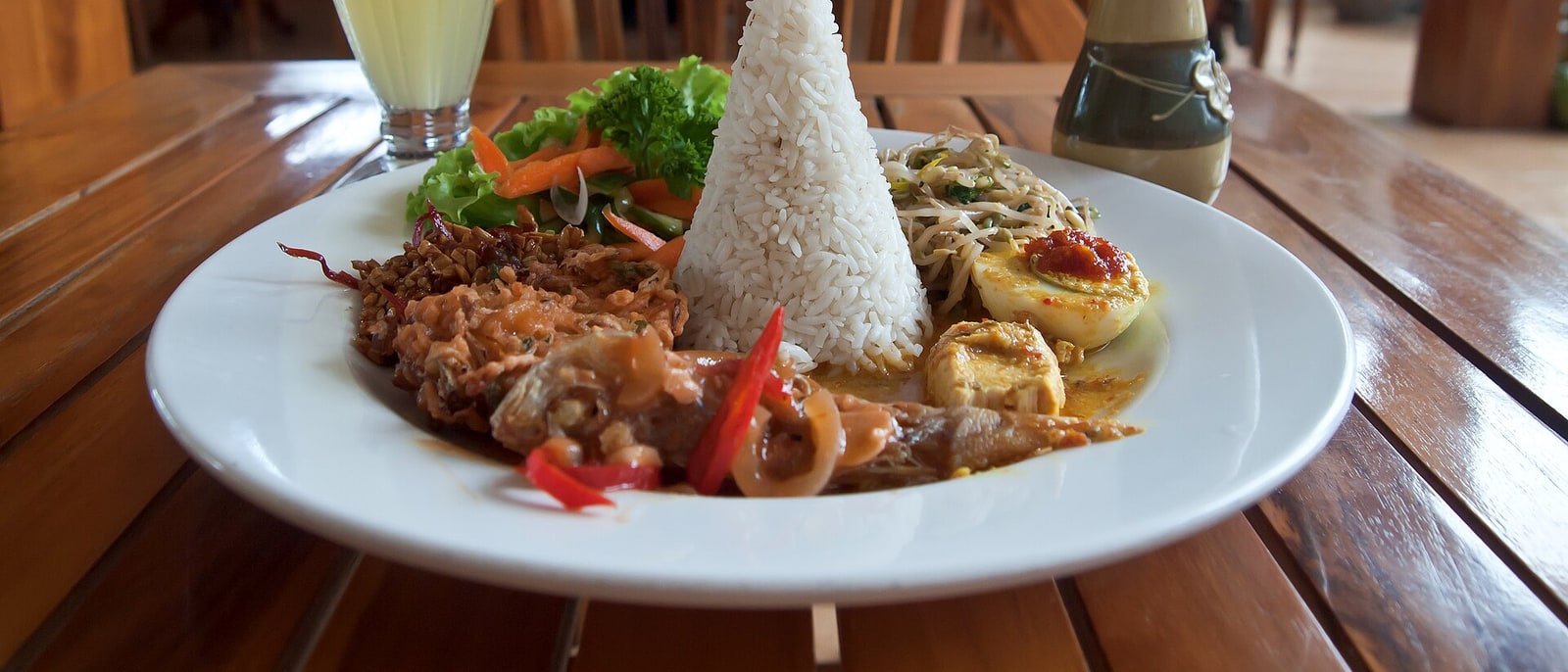 A Balinese nasi campur: rice in the middle, a ring of side dishes around it