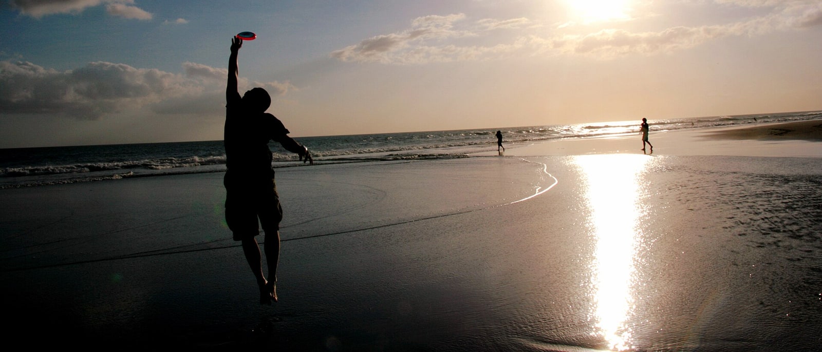 A backlit figure on Seminyak beach at sunset
