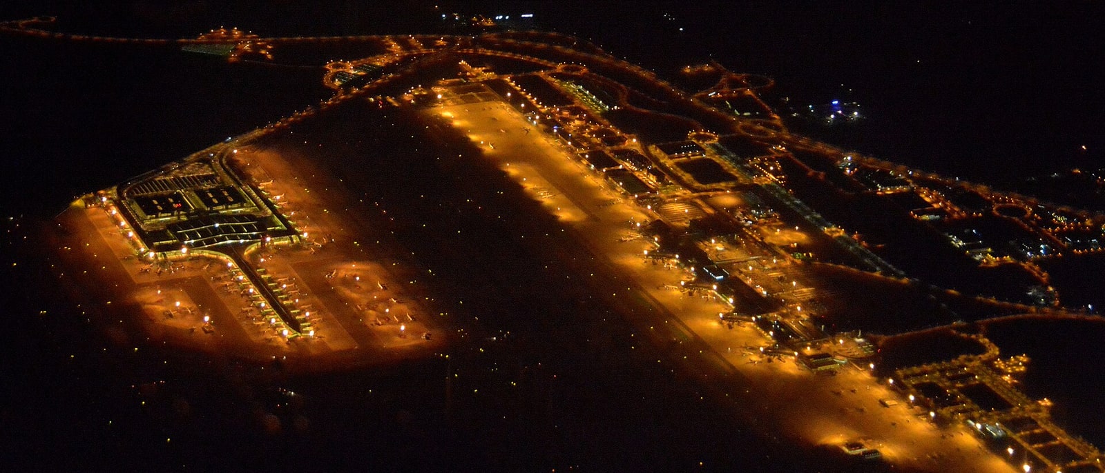 El Prat airport from the air at night, runways lit
