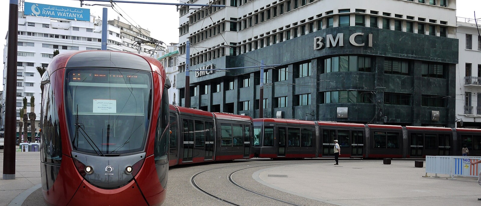 Un tranvía rojo de Casablanca tomando la curva ante el edificio del BMCI