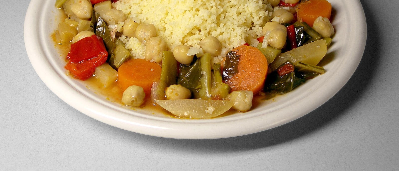 Un cuscús con verduras y garbanzos, servido en su fuente