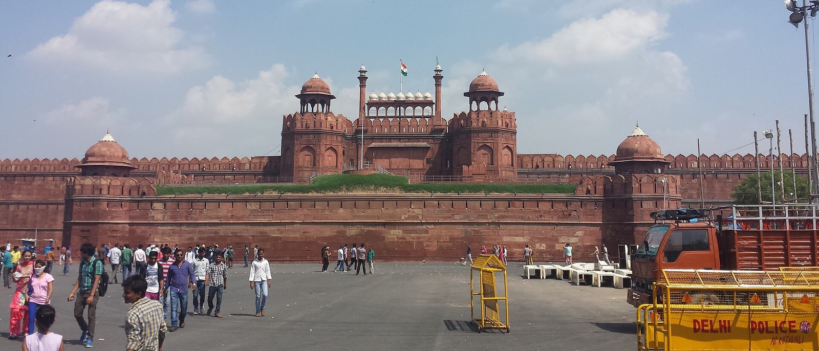 The red sandstone wall of the Red Fort, people at its foot