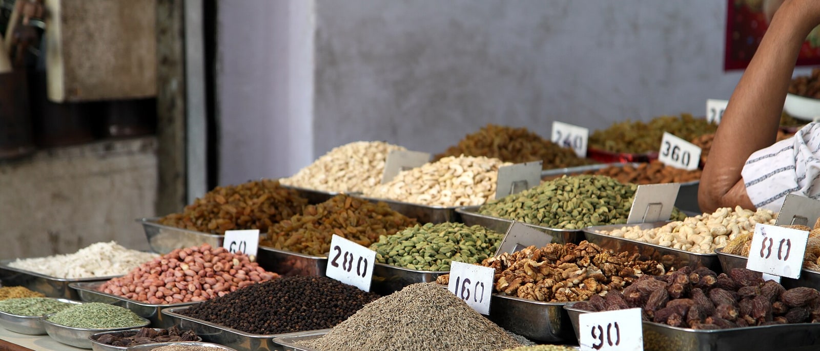 A spice and dried fruit stall with hand-written prices