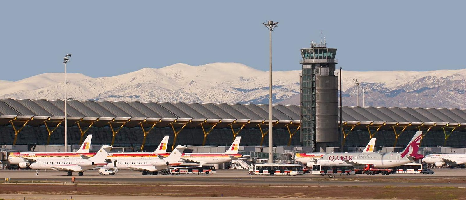 Aircraft parked at Barajas T4, the control tower and the mountains behind