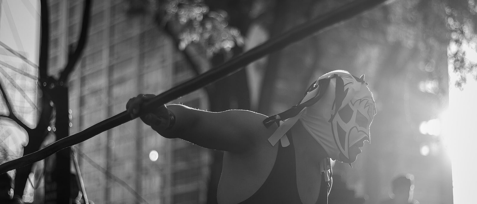 Un luchador enmascarado sobre las cuerdas del ring, en blanco y negro