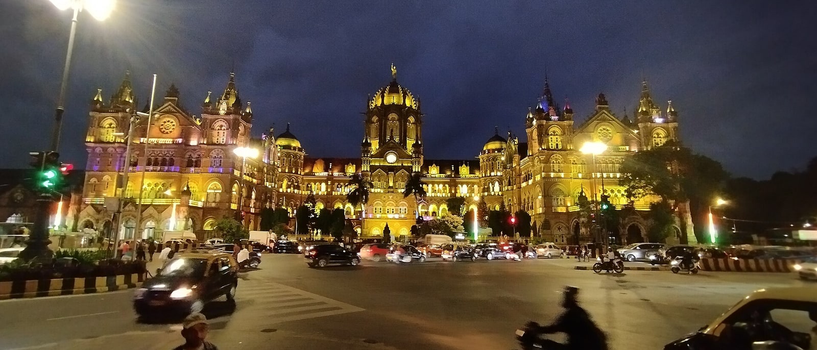 La estación CST iluminada de noche, con el tráfico delante