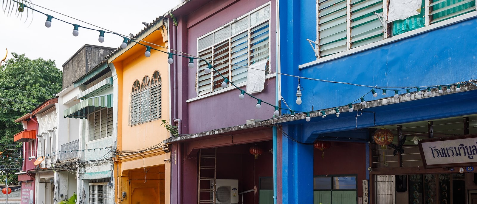 The Sino-Portuguese shophouses on Thalang Road, painted purple, orange and blue, strung with bulbs