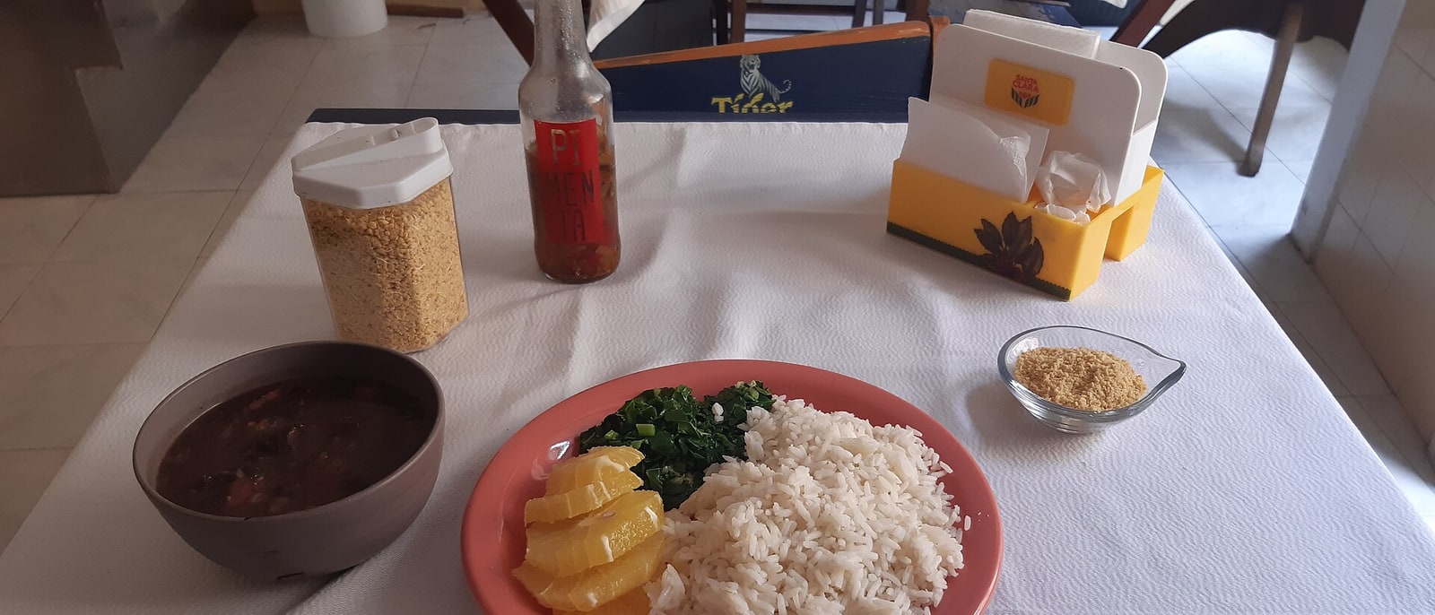 A plate of feijoada with rice, orange and farofa