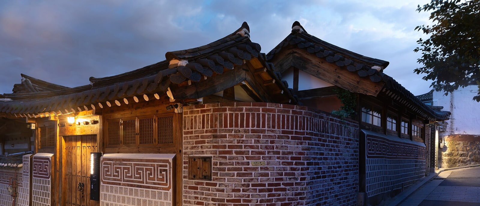 El tejado y el muro de una casa hanok de Bukchon, al anochecer