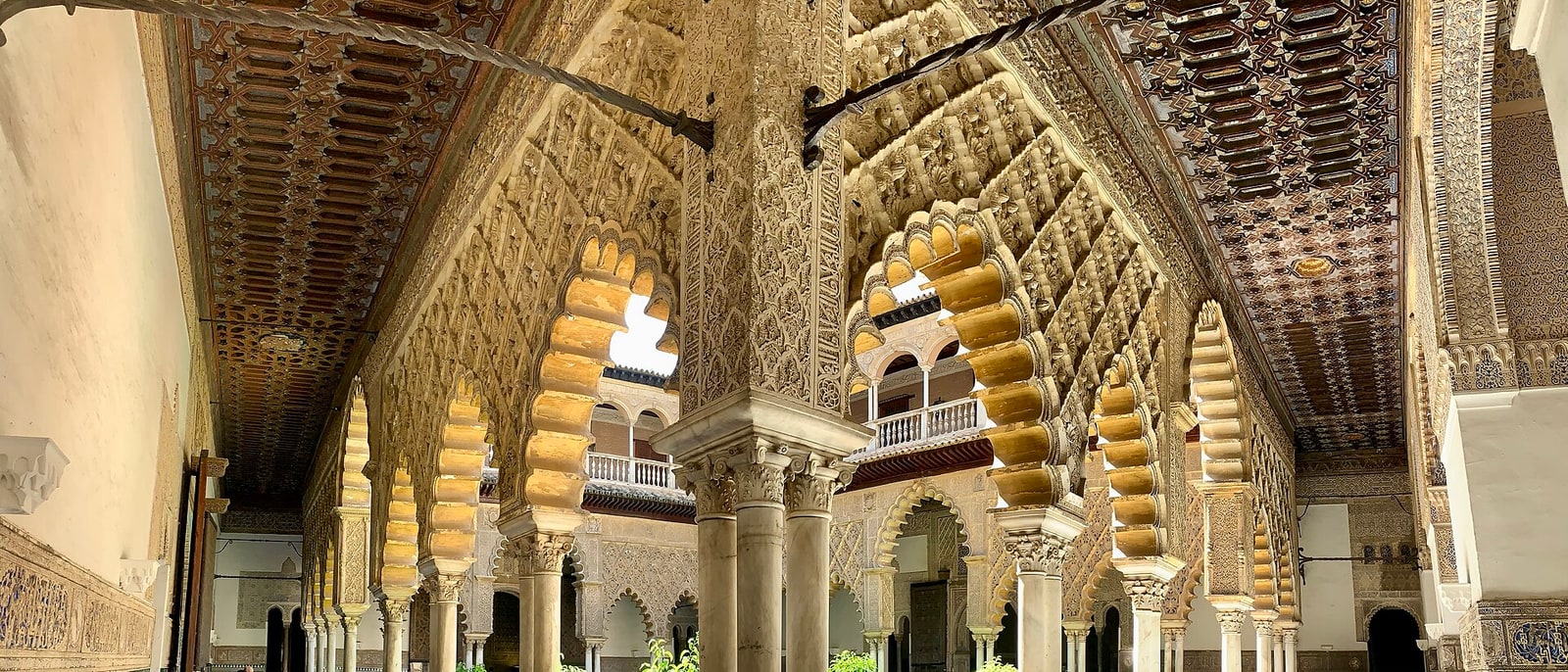 The carved plaster arches of the Patio de las Doncellas, inside the Real Alcázar