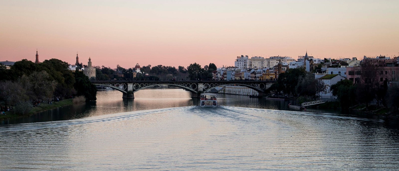 The Guadalquivir at dusk, the Triana bridge and the barrio on the far bank