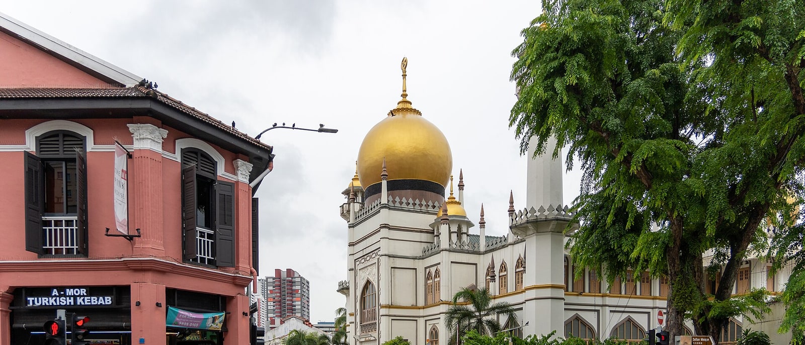 The golden dome of the Sultan Mosque in Kampong Glam, a pink shophouse in front