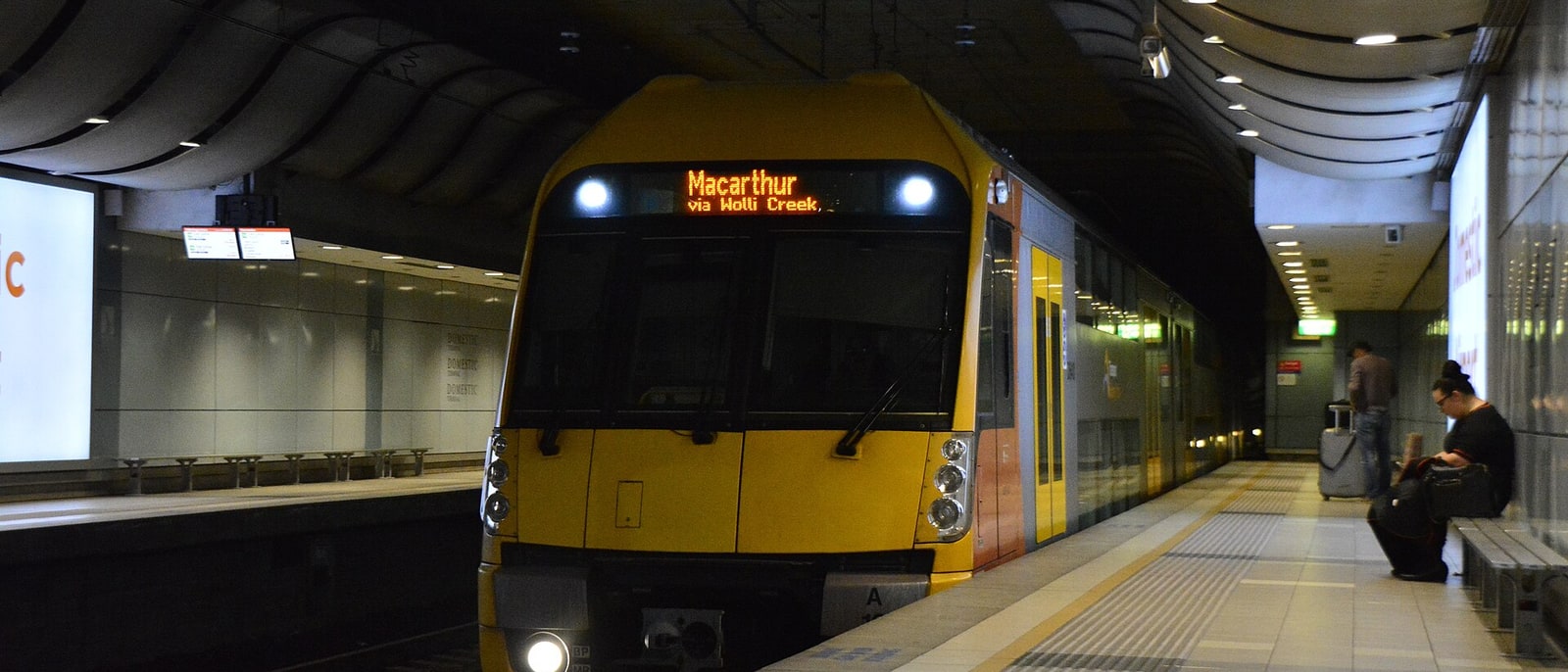 A yellow Sydney train at an underground platform
