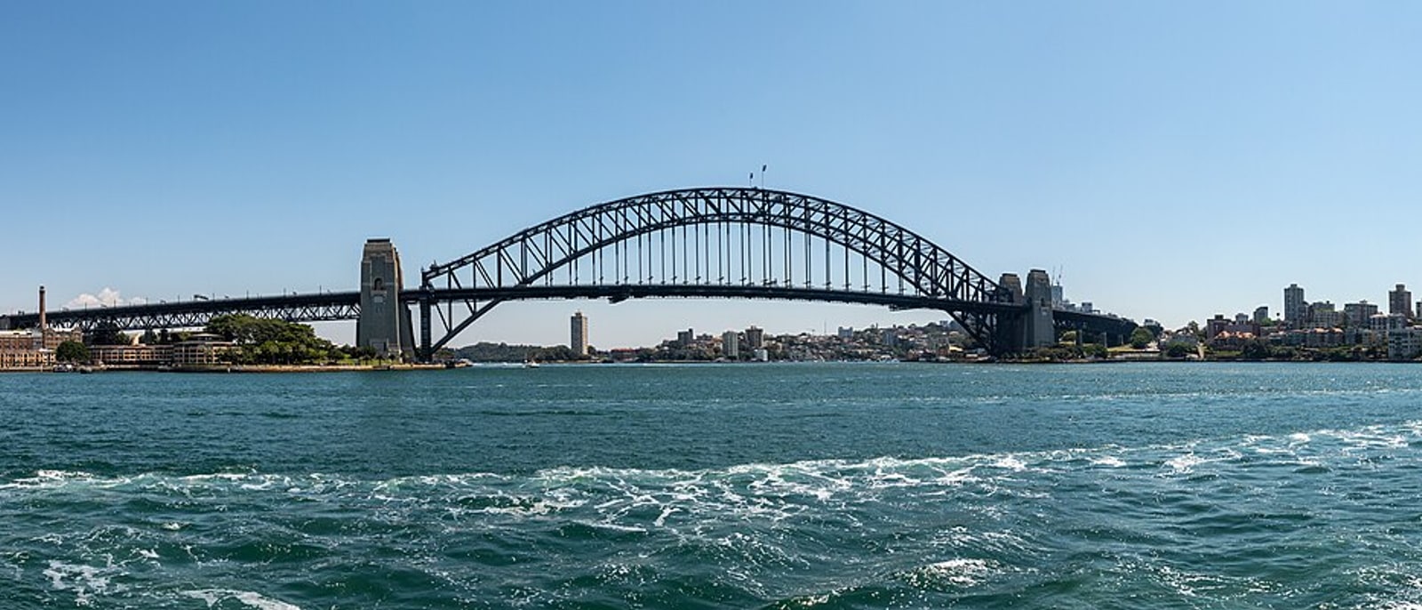 The Harbour Bridge spanning the harbour, seen from the shore