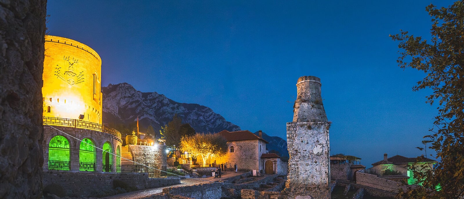 Kruja Castle lit up at night, above the town