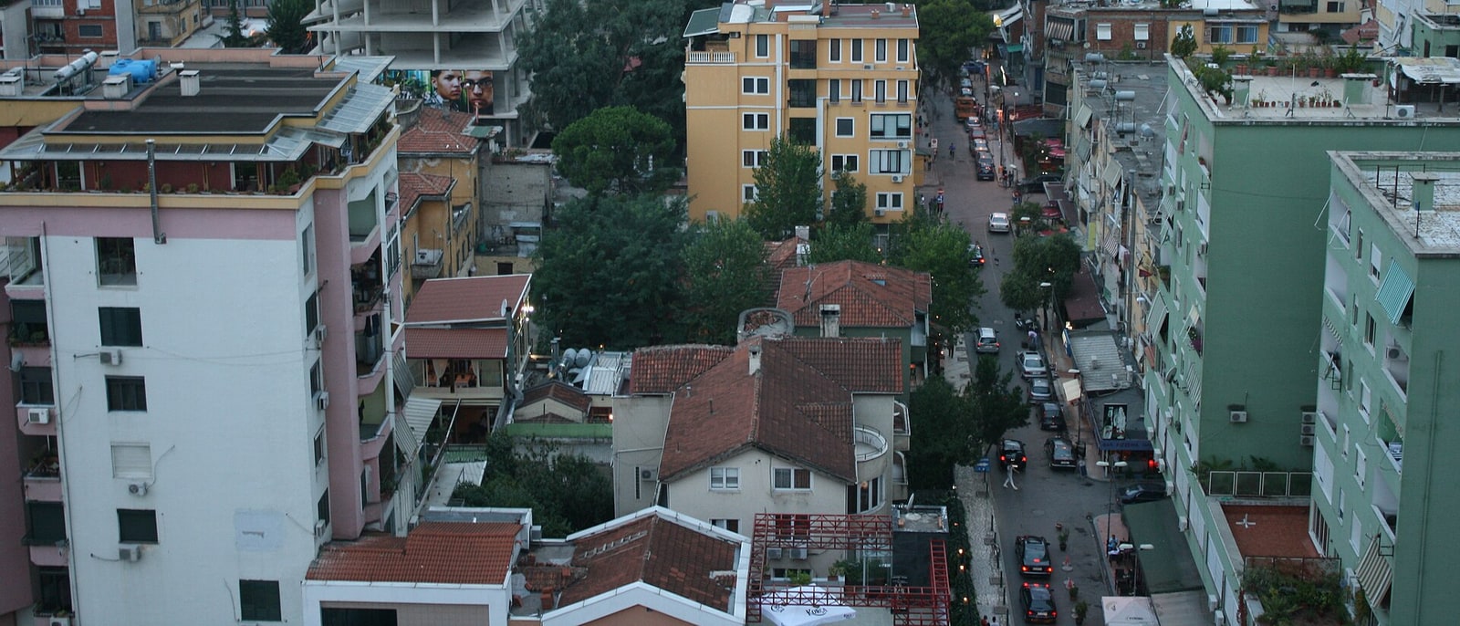 Tirana’s rooftops at dusk, mountains behind