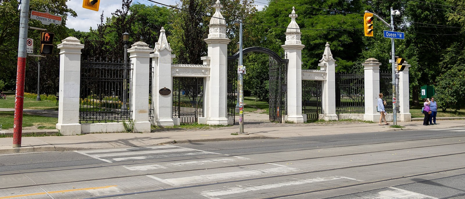 The stone gates of Trinity Bellwoods park, on Queen Street, with the streetcar rails in front