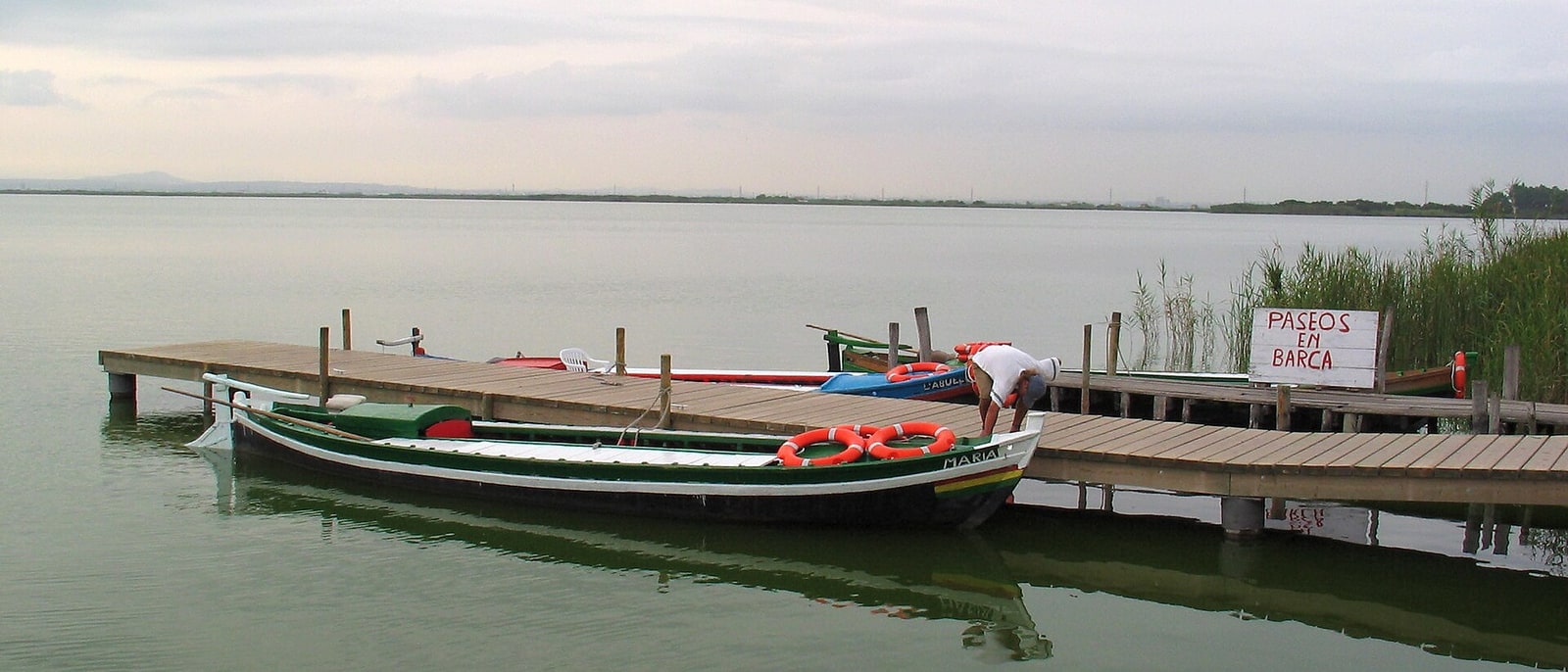 A boat moored at the Albufera jetty, the lagoon stretching behind