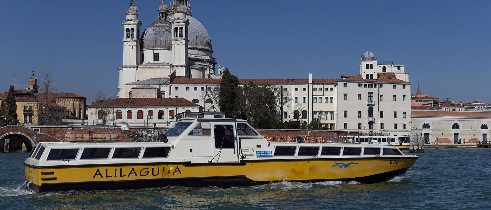 An Alilaguna boat crossing the lagoon, the Salute behind